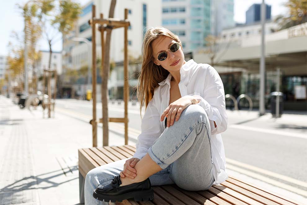 estilo natural esportivo mulher com roupas no estilo natural esportivo sentada em um banco de praça