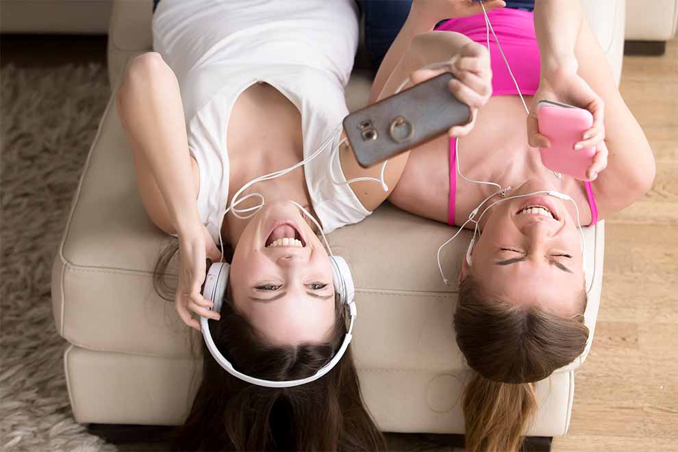 duas garotas escutando músicas da playlist personalizada para a festa do pijama