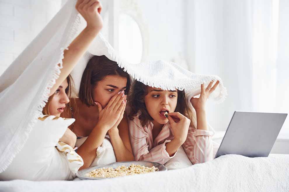 amigas fazendo uma festa do pijama e maratonando filmes de terror 