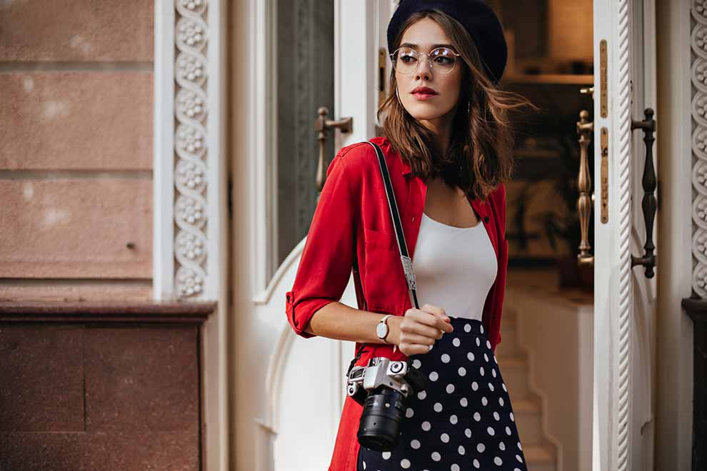 Mulher com camisa vermelha e câmera na mão