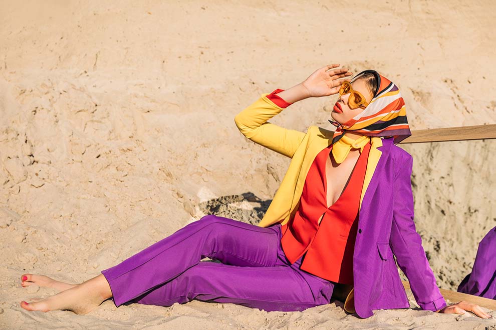 Mulher elegante com terno colorido na praia
