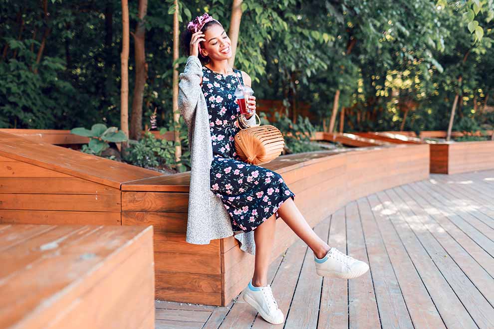  jovem sorrindo em ambiente natural, vestindo vestido floral