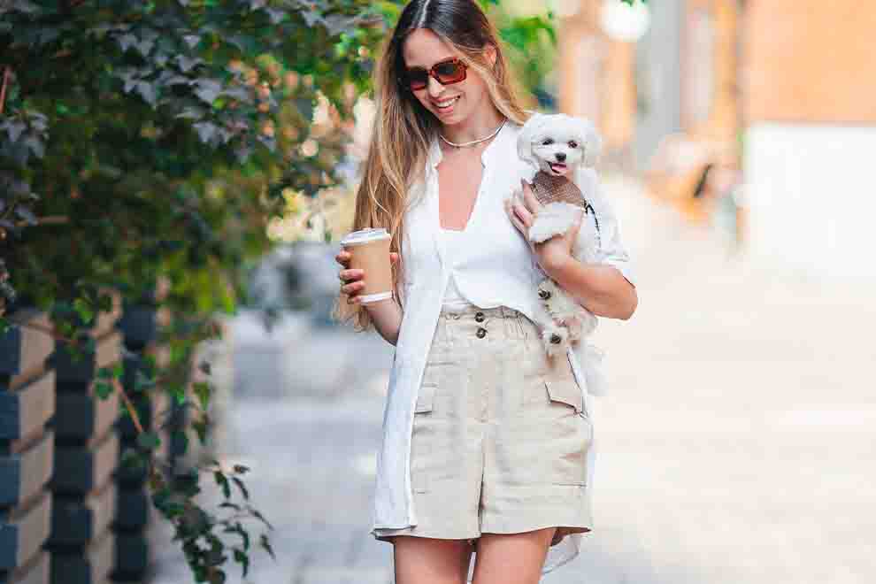 Mulher com cachorro e café em passeio ao ar livre