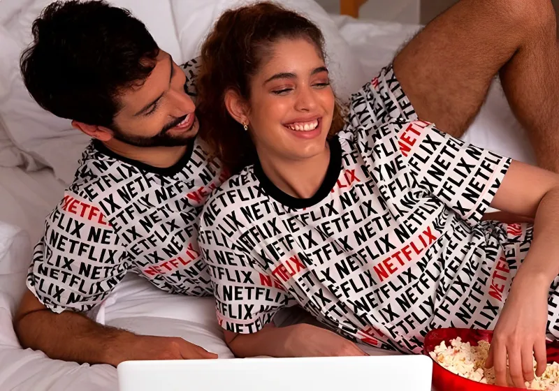 casal sorrindo com pijama da netflix 
