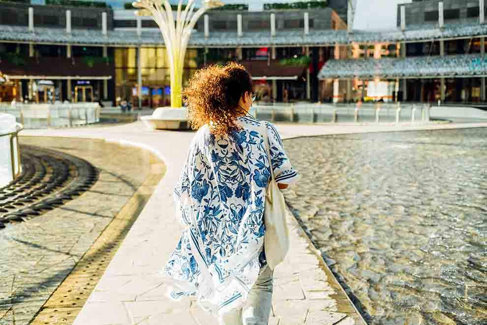 Mulher caminhando perto de fonte em shopping