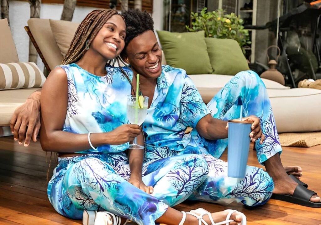 looks de casal combinando casal sorridente sentados no chão da varanda tomando drink com look combinado