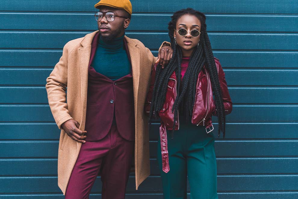 um casal de modelos usando roupas com cores analogas e complementares em um fundo de container